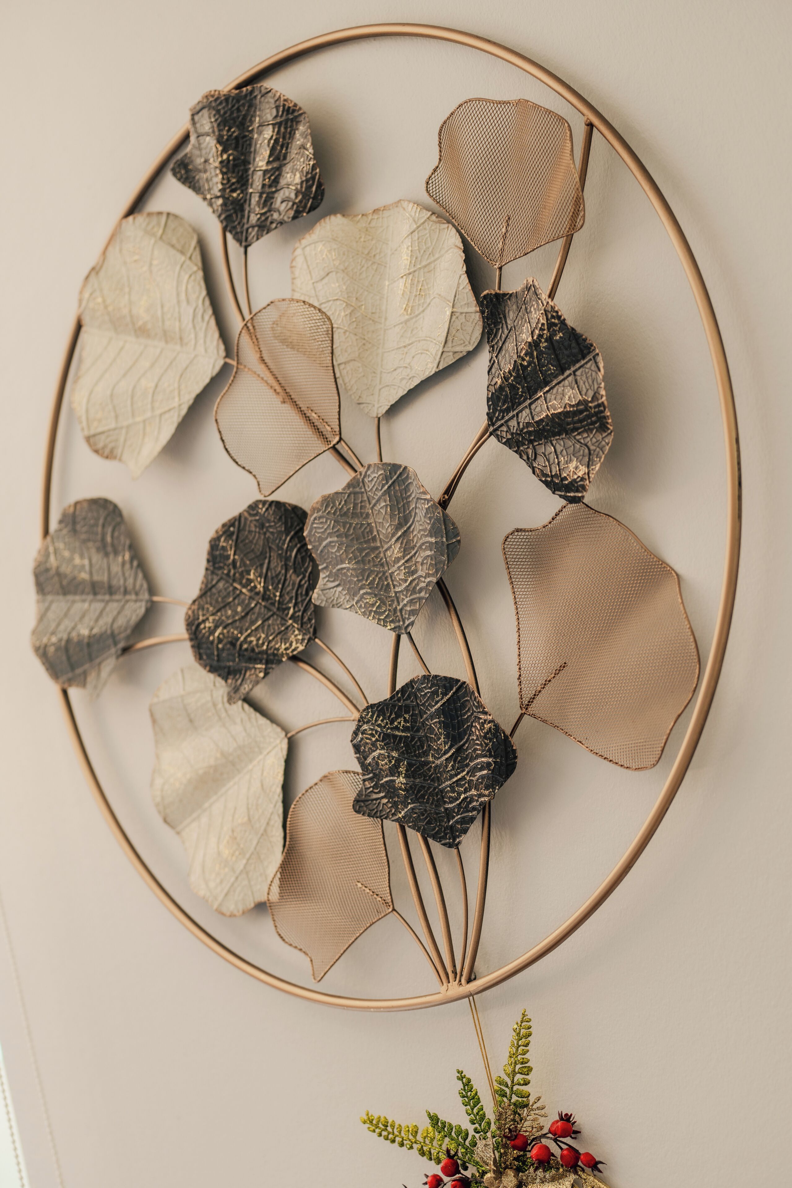 A wall-mounted decorative piece with leaf-like elements and a circular frame.