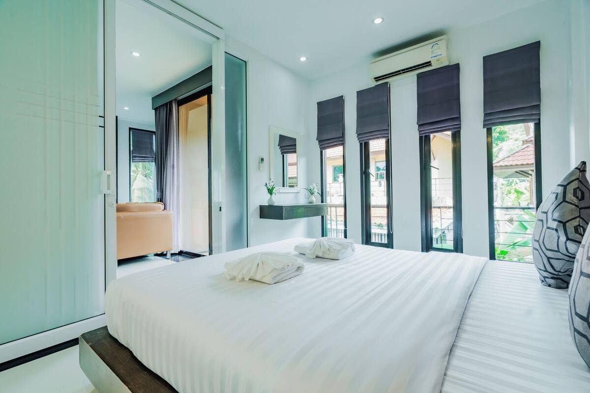 Una moderna camera d'albergo con un letto grande, un divano, un bagno e vista sull'esterno.