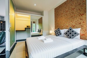 Een hotelkamer met een bed, een spiegel, een kledingkast en een badkamer.