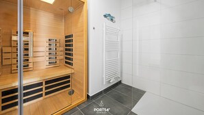 Un baño moderno con tocador de madera, radiador blanco y suelo de baldosas.
