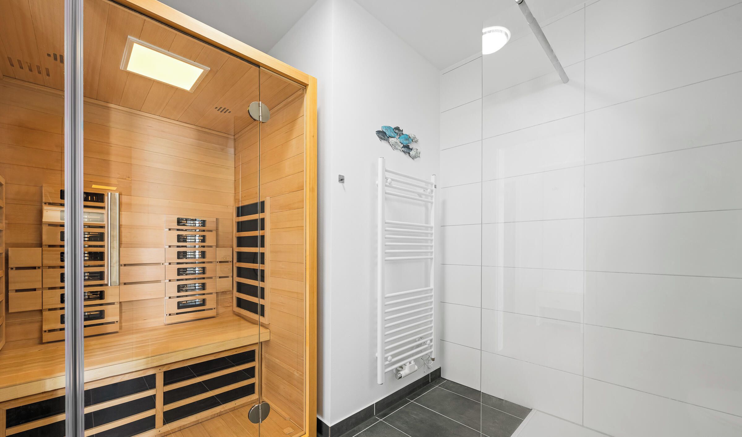 Een moderne kamer met een houten garderobe, een witte radiator en een betegelde vloer.