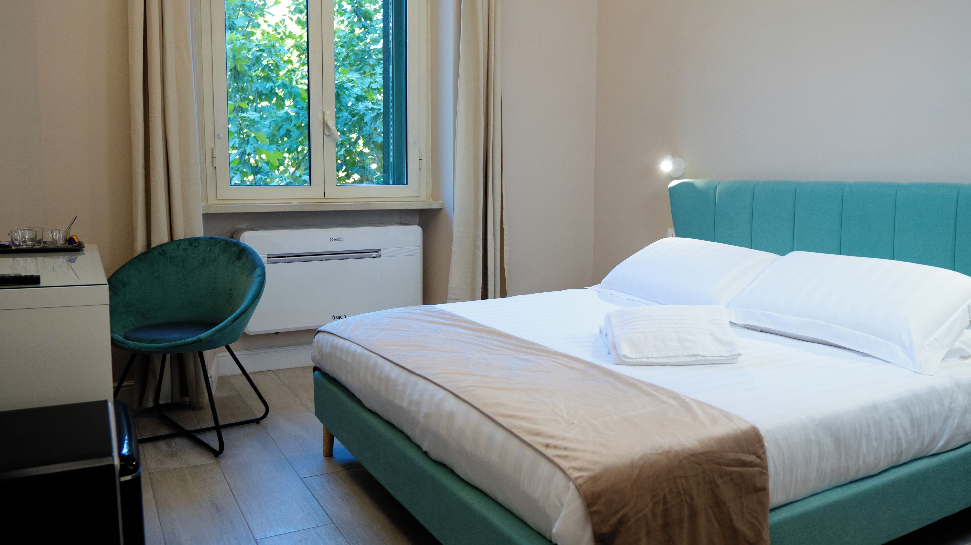 A bedroom with a bed, a desk, and a chair.