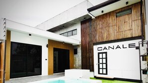 Ein modernes Haus mit Swimmingpool und überdachter Terrasse, mit einem Schild mit der Aufschrift 'CANALE'.