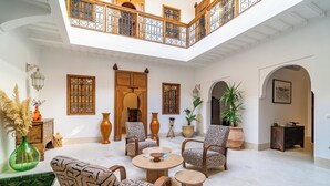 A spacious, well-lit interior with a high ceiling, a central seating area with patterned chairs, and a balcony with decorative railings. - Riad Sofia Marrakech (Marrakech)
