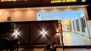 A multi-story building with a sign for AC/Non AC rooms.