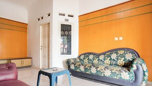 Une pièce avec un canapé, une petite table et une porte portant un numéro.