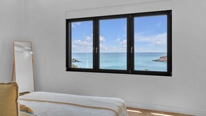 Une chambre avec une grande fenêtre donnant sur la côte.