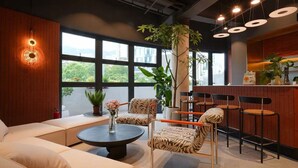 Un intérieur moderne avec un espace salon, un bar et de grandes fenêtres.