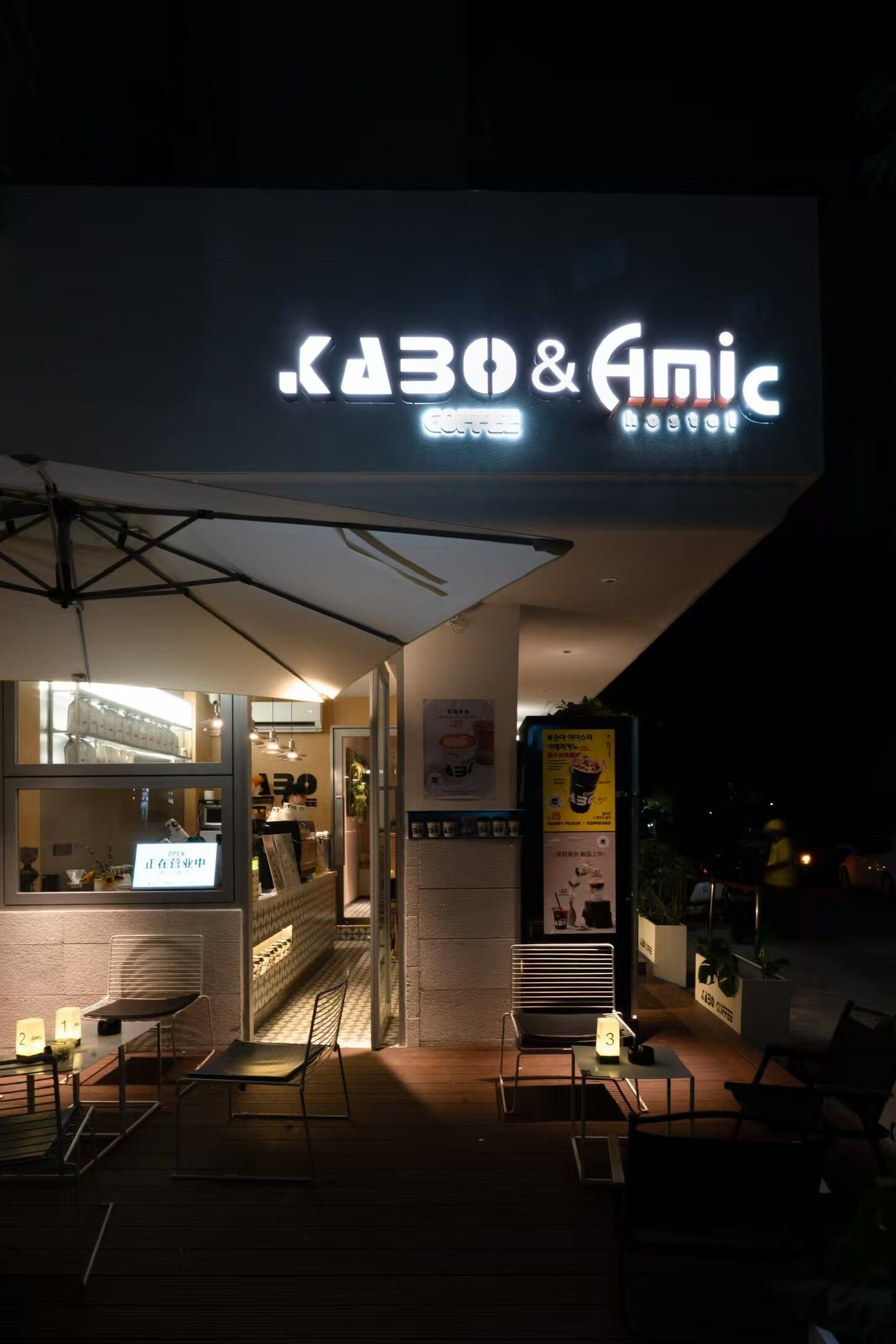 Uma cafeteria com uma placa que diz 'KABO & Anic' e um cardápio de café.