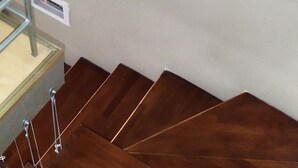 A wooden staircase with metal handrails and a metal ladder.