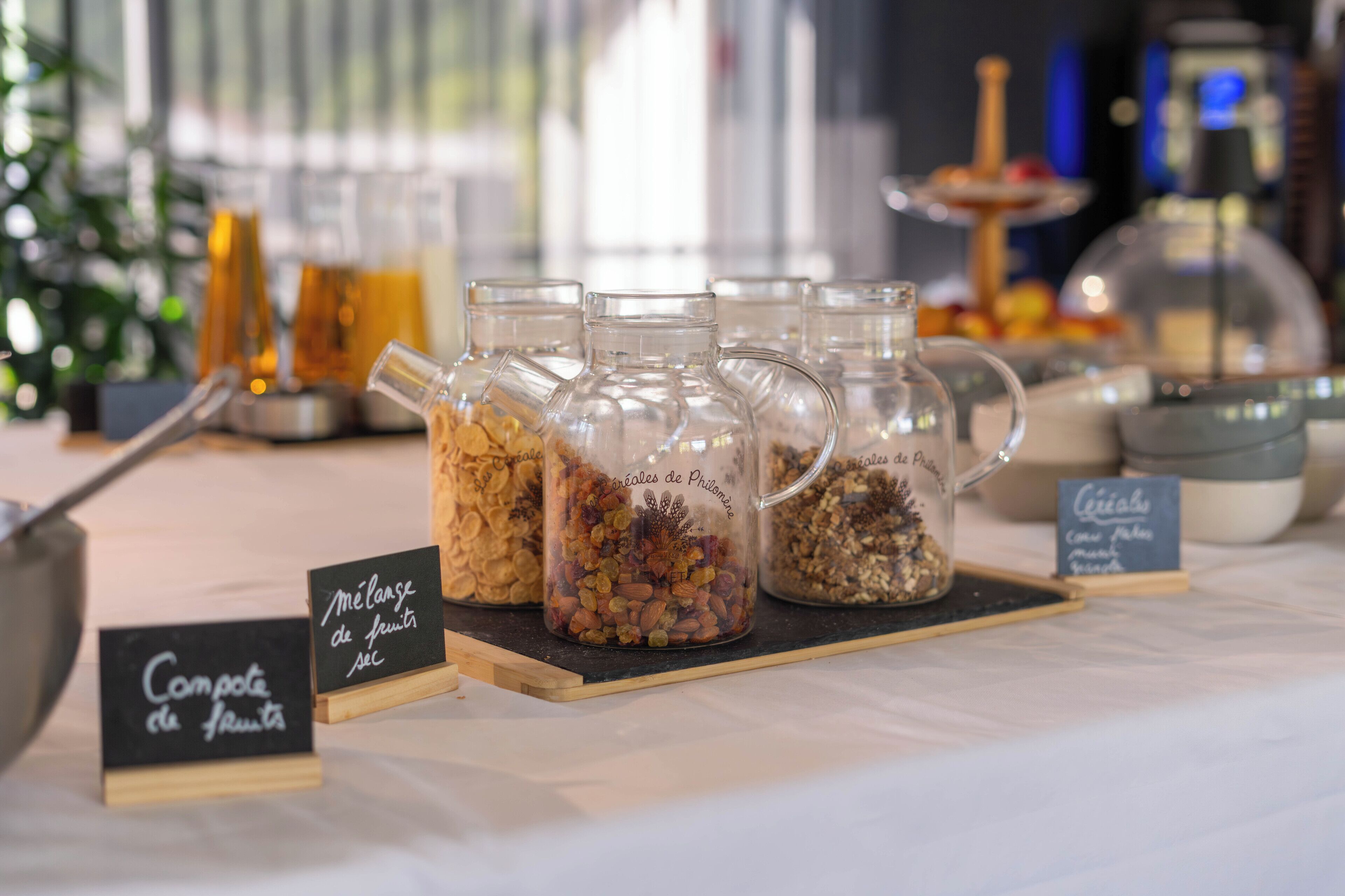 Un tavolo con buffet assortito di frutta e noci, contenitori etichettati.