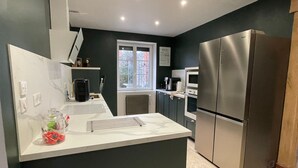 A modern kitchen with a central island, stainless steel appliances, and a window providing natural light.