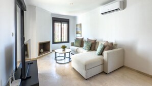 A modern living room with a sofa, a small round table, and a fireplace.