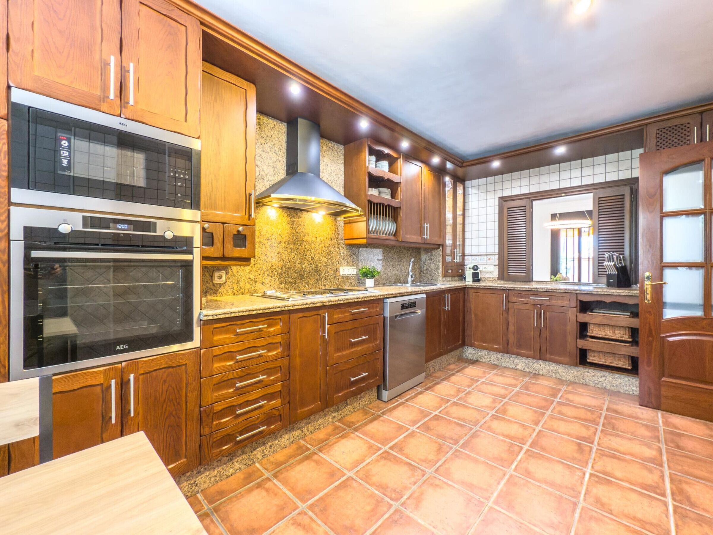 A kitchen with wooden cabinets, a microwave, oven, and a dishwasher.