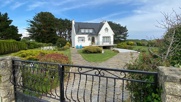 A white house with a stone pathway leading to a blue door.