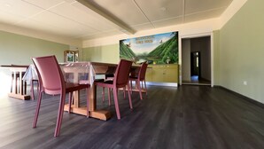 A dining area with a table and chairs, a kitchen counter, and a mural on the wall. - Authentic farmhouse room, Saint-Benoît (Saint-Benoît)