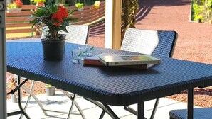 An outdoor seating area with a table, chairs, and a potted plant. - Authentic farmhouse room, Saint-Benoît (Saint-Benoît)