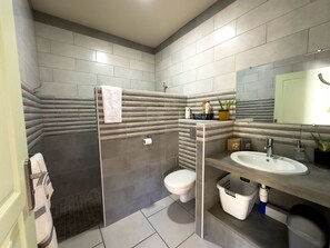 Ein modernes Badezimmer mit Dusche, Toilette und Waschbecken.