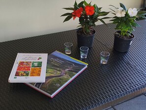 Una mesa con un libro, dos macetas y tres vasos pequeños.