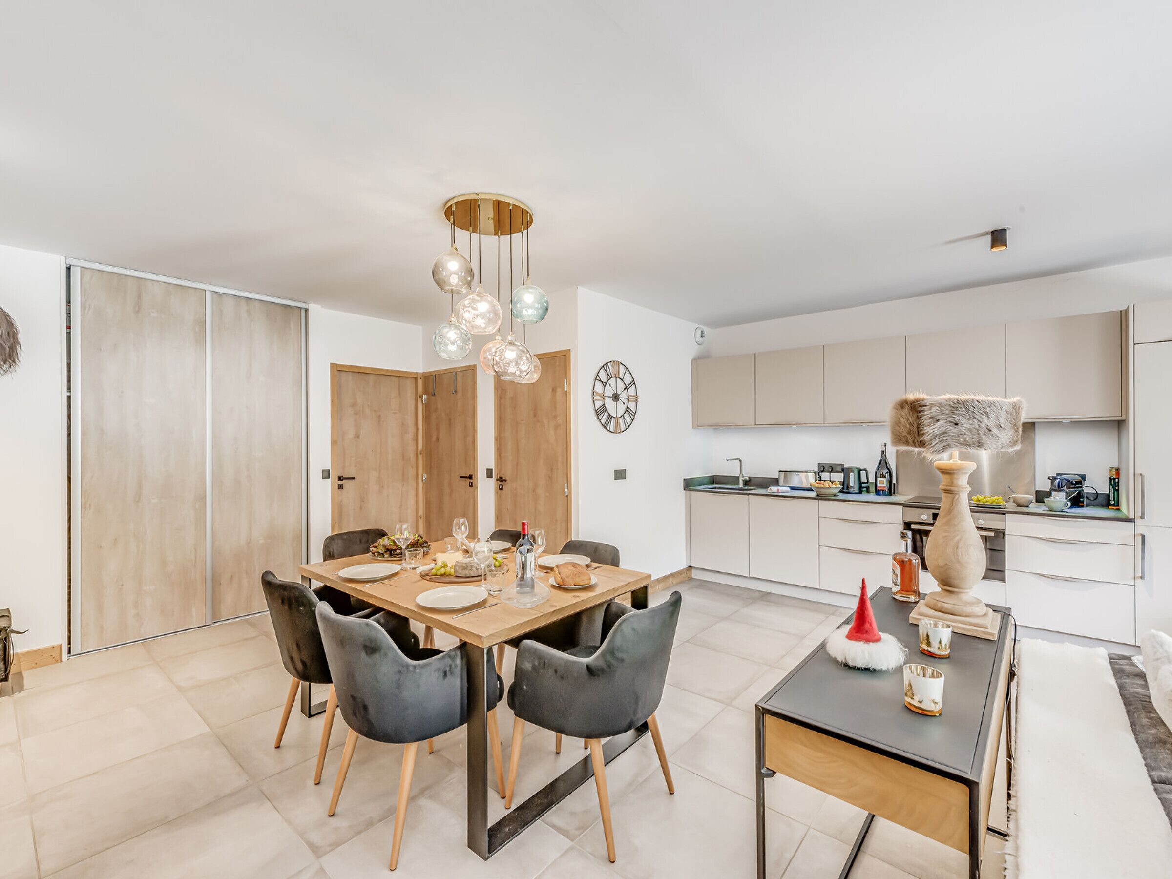 Una cocina moderna con una isla central, armarios de madera y un comedor con mesa y sillas de madera.