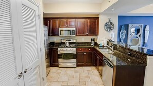 A kitchen with dark wooden cabinets, a stainless steel stove, and a microwave.