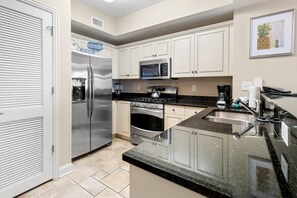 A kitchen with a stainless steel refrigerator, microwave, stove, and oven.