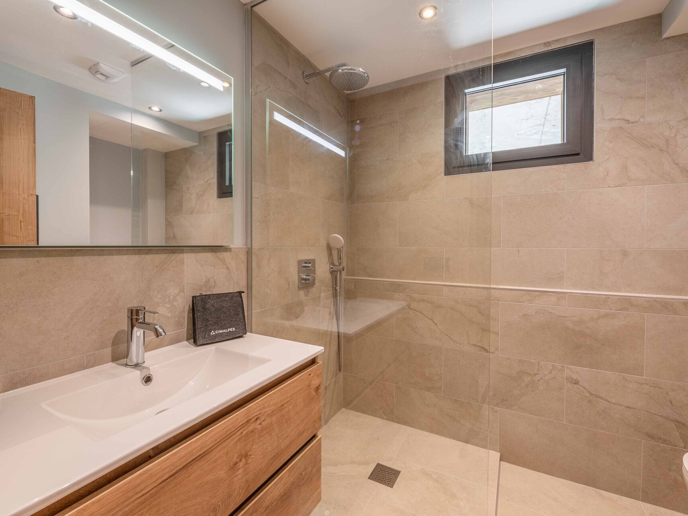 A modern bathroom with a glass shower enclosure, a vanity with a sink, and a mirror.
