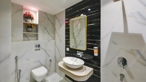 Et moderne badeværelse med toilet, håndvask og brusebad.