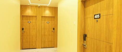 A hallway with two wooden doors, each marked with a number.