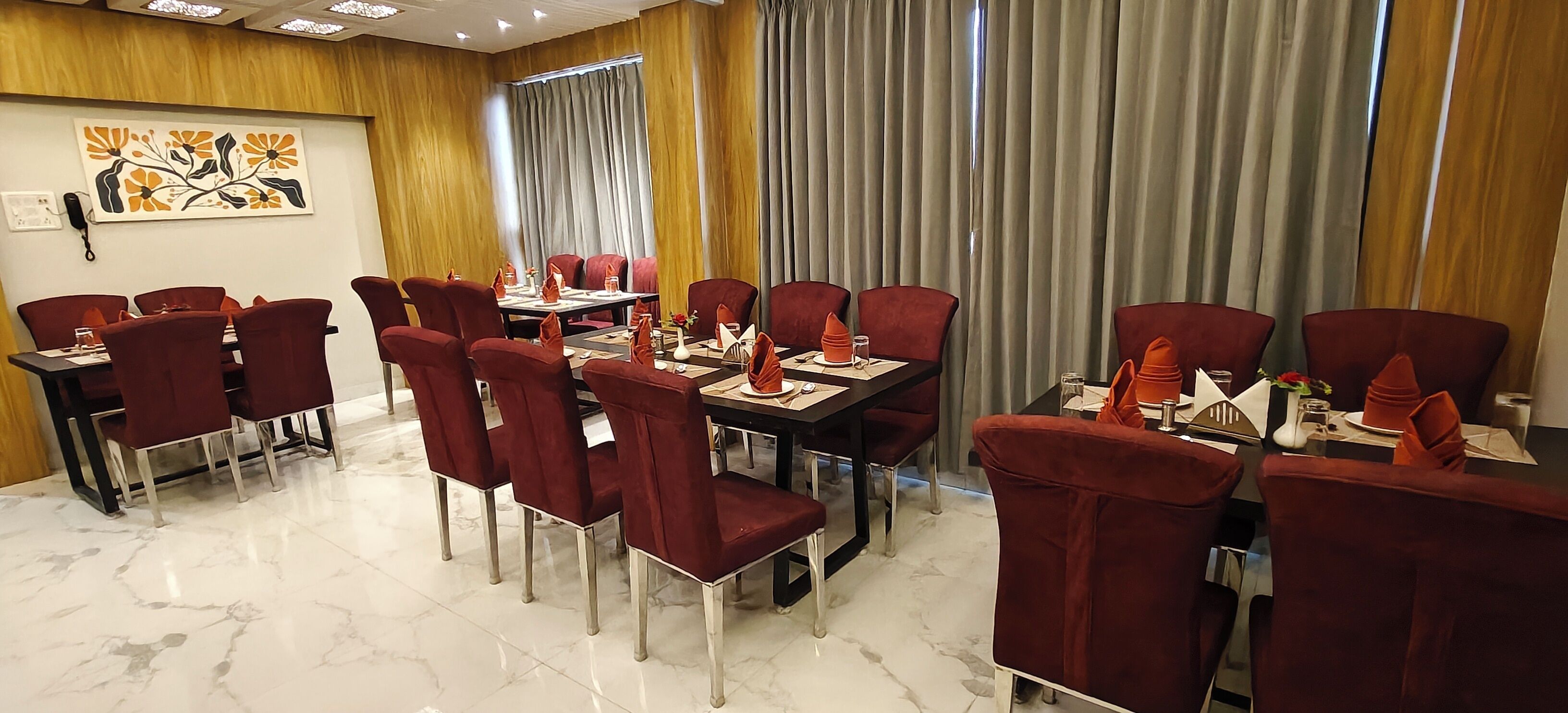 A conference room with red chairs, a marble floor, and a large window with curtains.