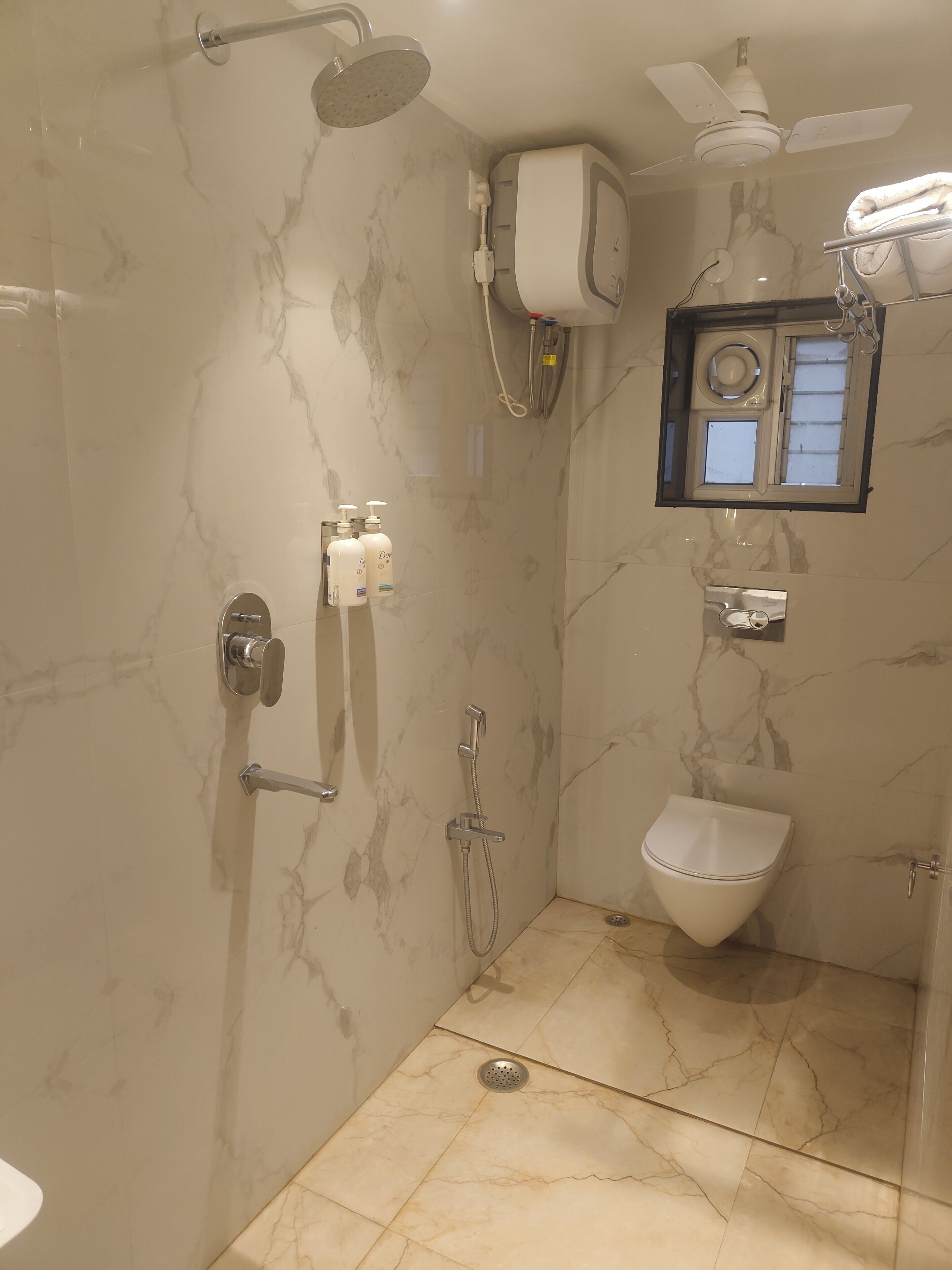 Un baño con ducha, inodoro y ventana.