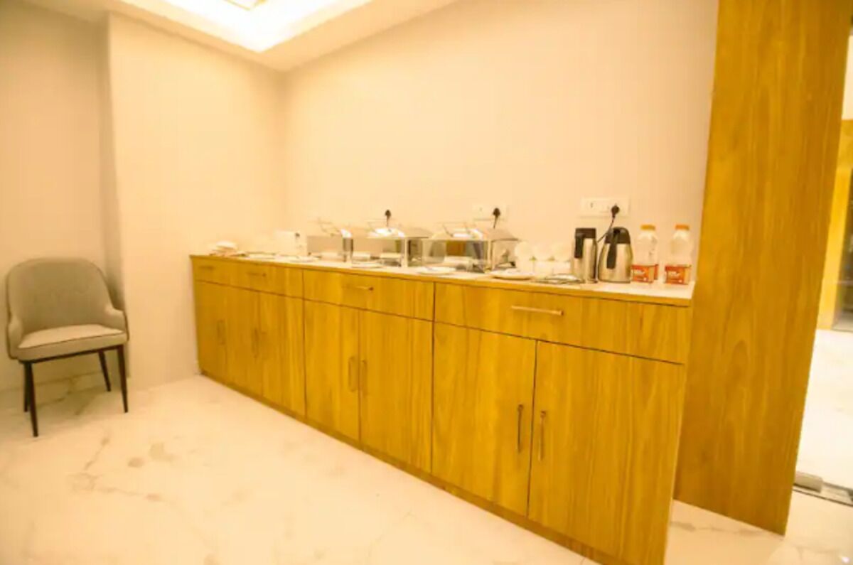 Una habitación con un armario de madera, una silla y una encimera con diversos objetos.