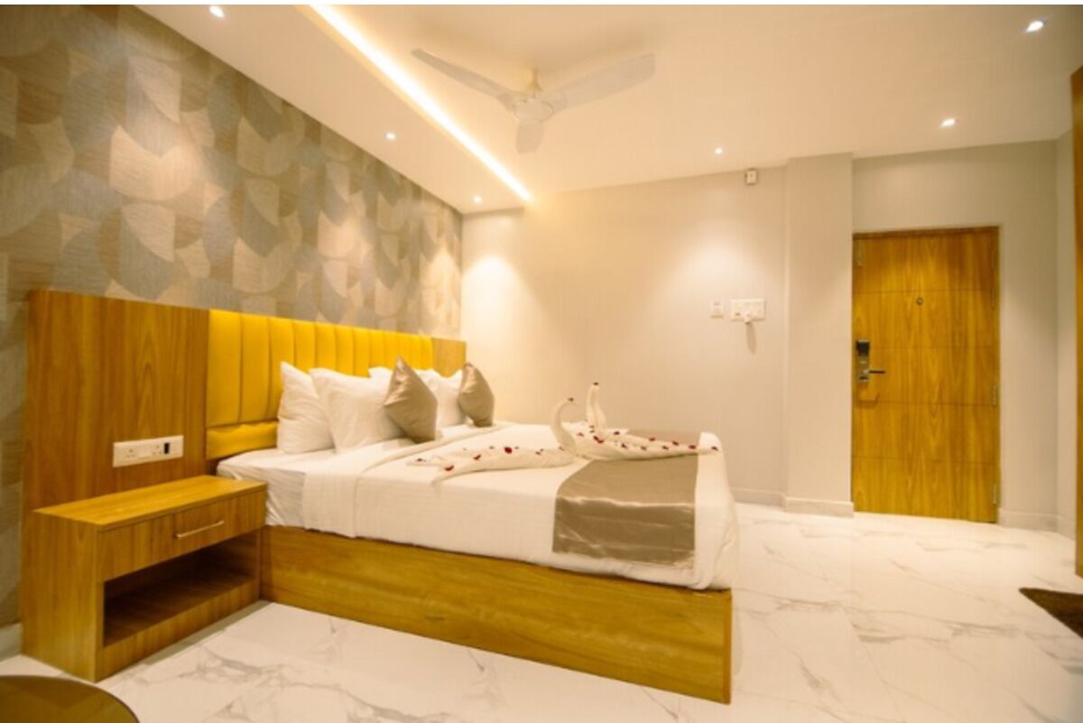 A modern bedroom with a wooden headboard, a bedside table, and a marble floor.