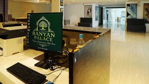 Eine Rezeption im Banyan Palace mit Computerbildschirm, Tastatur und einer Wasserflasche.