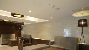 Ein modernes Wohnzimmer mit Sofas, einem Couchtisch und einer Lampe.