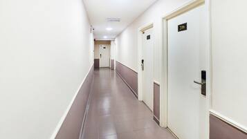 A long, narrow hallway with doors on one side, each marked with a number.