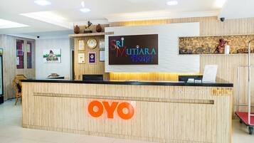 Un mostrador de recepción con detalles de madera y un gran letrero que dice 'OYO'.
