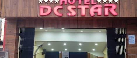 La entrada del Hotel DC Star, con un letrero llamativo y una escalera que conduce al interior.