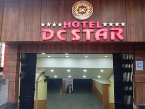 The entrance of Hotel DC Star with a prominent sign and a staircase leading inside.