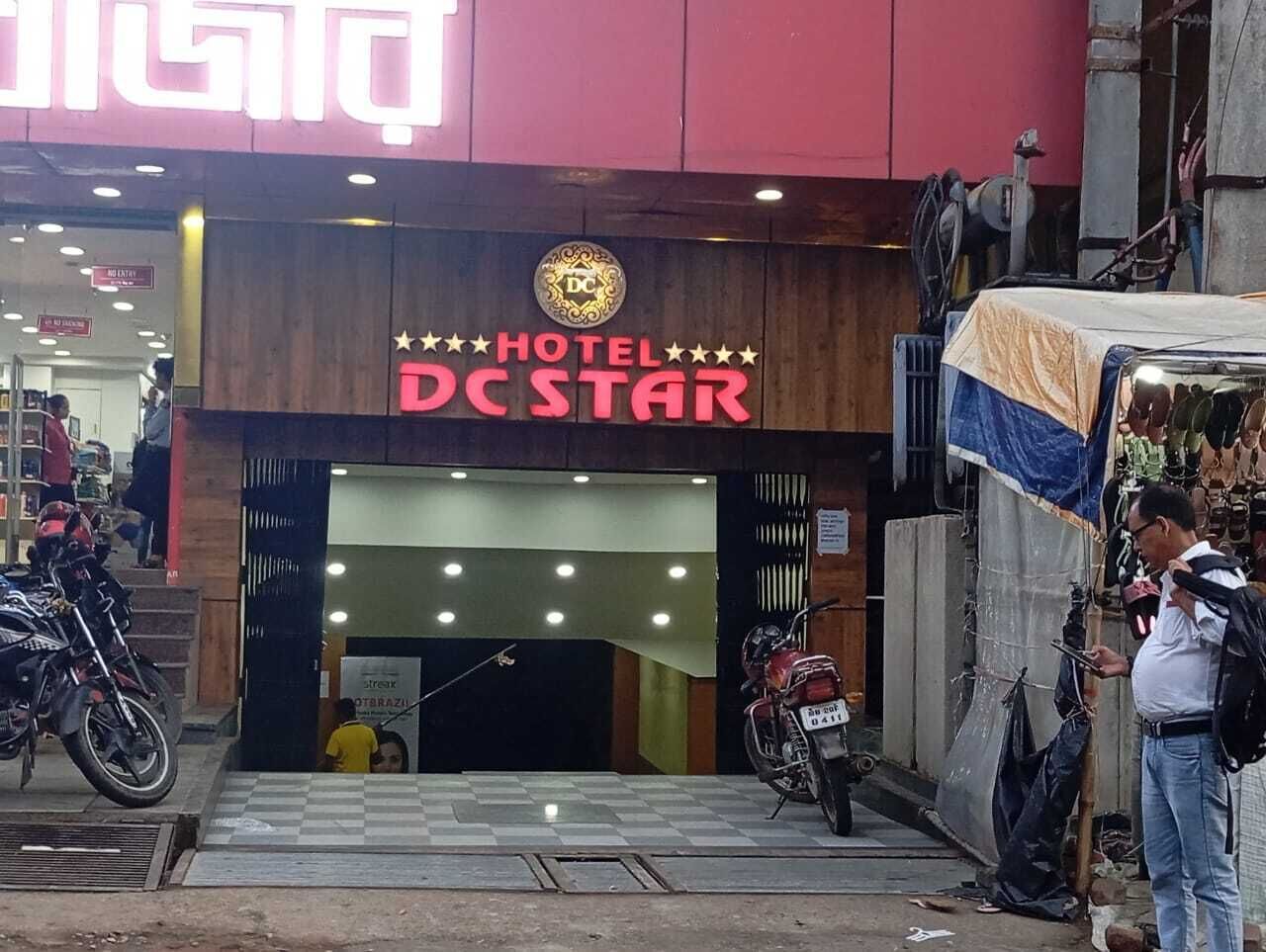 La entrada al Hotel DC Star, con un cartel sobre la puerta y una motocicleta estacionada afuera.
