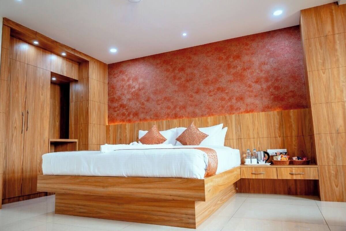 A modern bedroom with a wooden bed frame, a nightstand, and a built-in wardrobe.