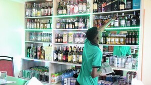 A bar area with shelves stocked with various liquor bottles and cans. - The Tag Hotel  (Juja)