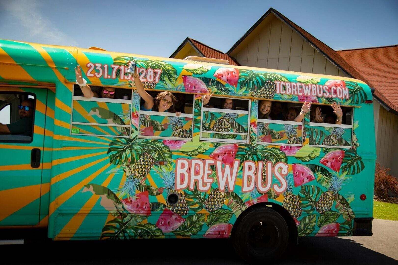 A colorful bus with tropical designs and the text 'BREW BUS' and 'TCBREWBUS.COM'.