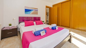 Habitación de hotel con una cama, una mesita de noche, un armario de madera y un cuadro en la pared.