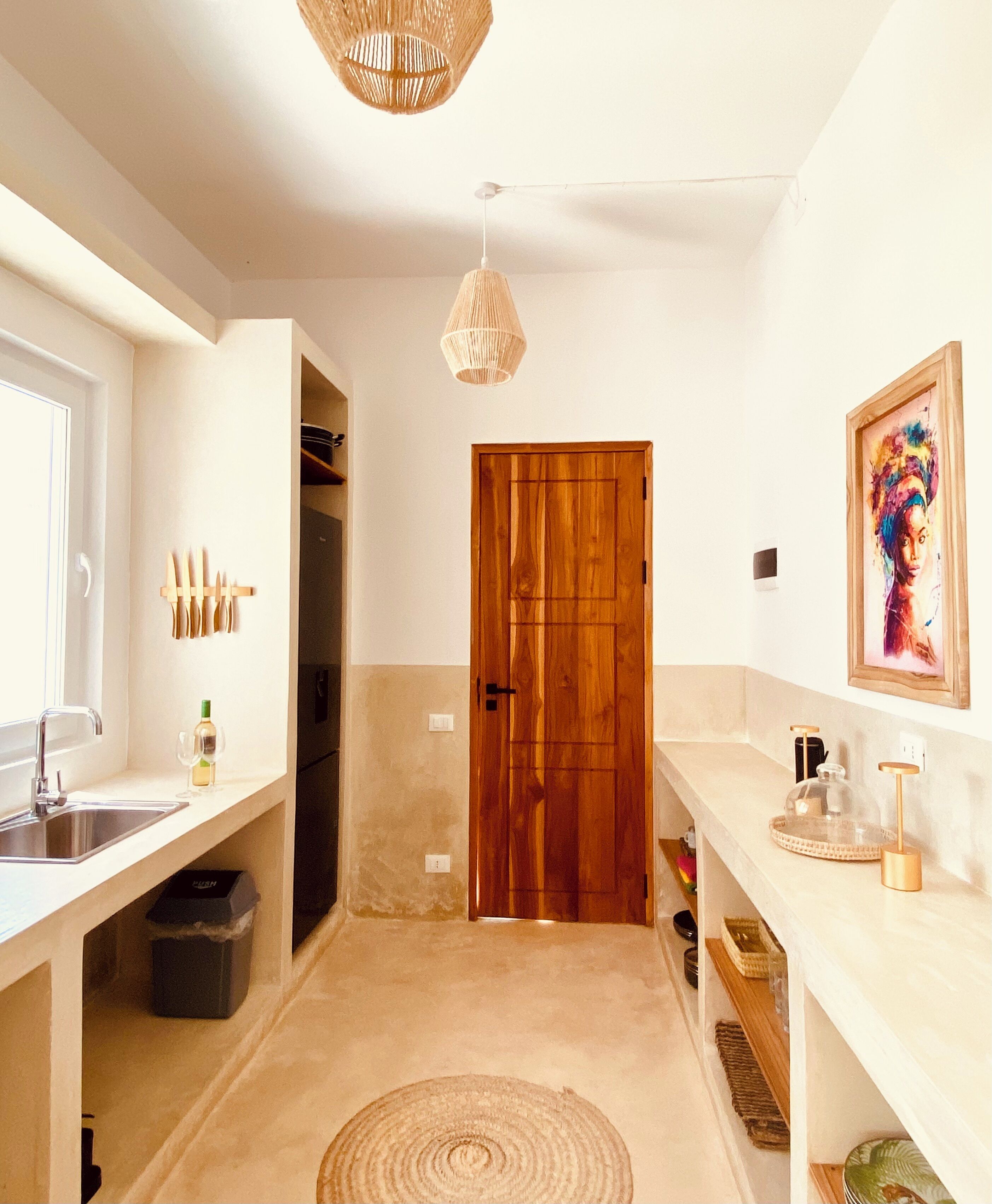 Eine moderne Küche mit Holztür, Spüle und Arbeitsplatte mit einem Glasbehälter.