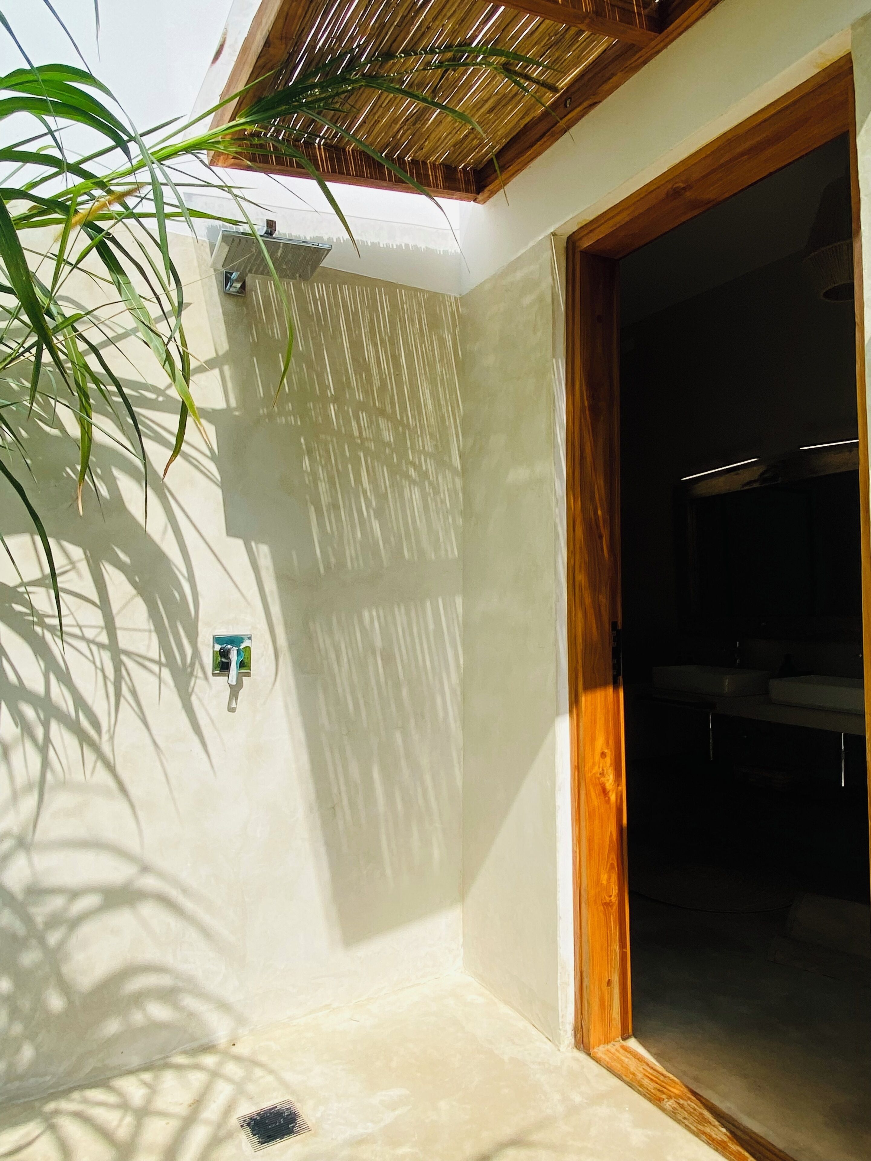 Un baño con ducha, lavabo y puerta de madera.