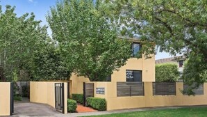A gated entrance with a pathway leading to a building with a flat roof and a window. - Quiet, peaceful northcote 1 bedroom unit (Northcote)