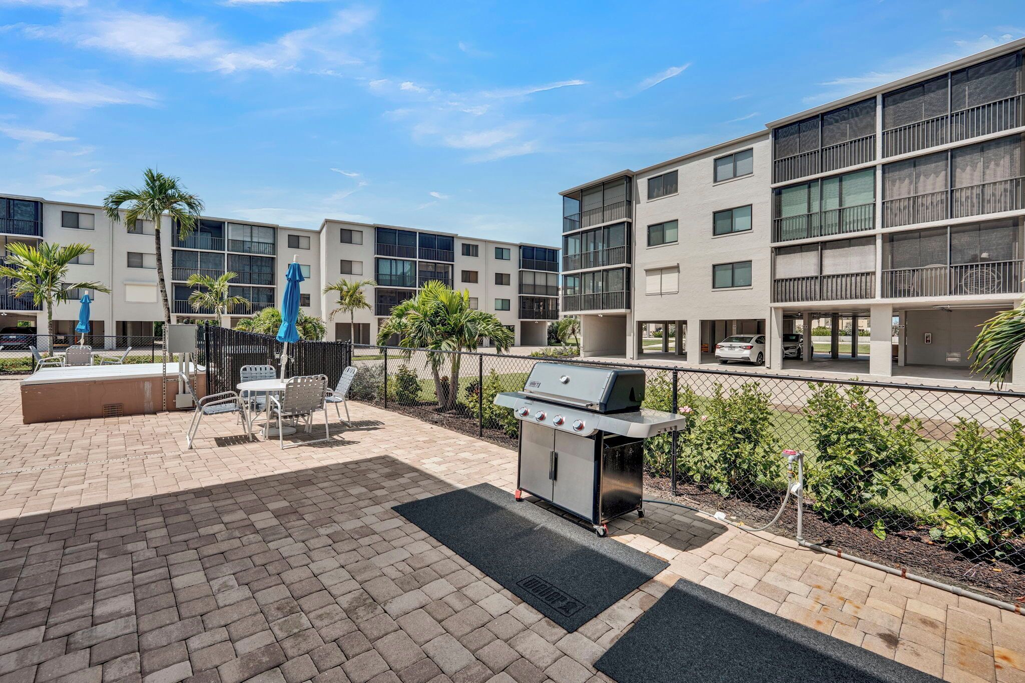 Un espace extérieur moderne, aménagé en terrasse, avec un barbecue, des sièges et une piscine.