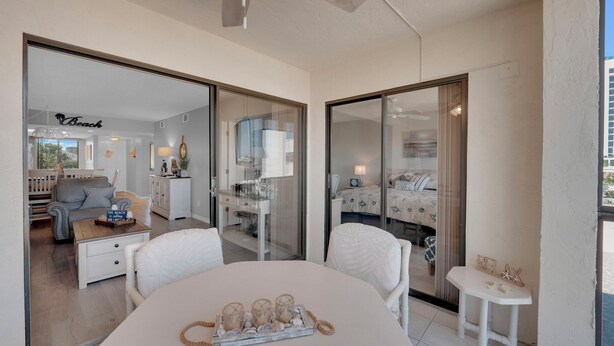 A modern bedroom with a large bed, a bedside table, and a window. - 2B/2B Fairview Isles 222 Condo, Walk to Beach, Heated Pool! (Fort Myers Beach)