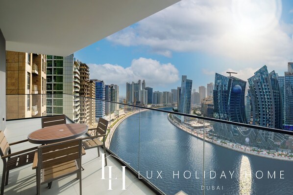 A balcony with a view of Dubai's skyline and water.